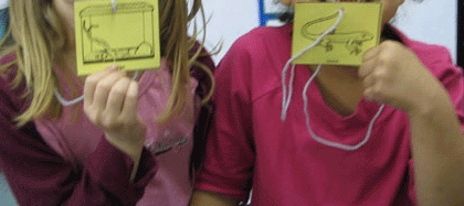 Students wearing animal and habitat picture necklaces for a matching activity